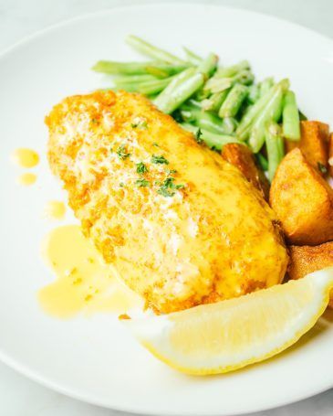 Fried chicken steak with lemon and vegetable in white plate