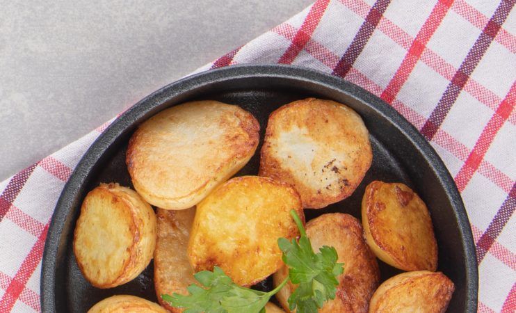 Slices of fried potatoes on black plate. High quality photo